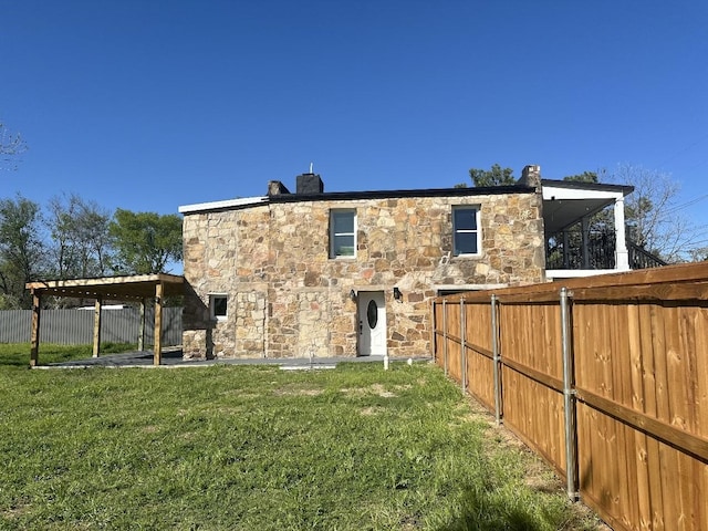 414 Ussery, Bowie, TX 76230 - back of house featuring stone siding, a yard, and fence