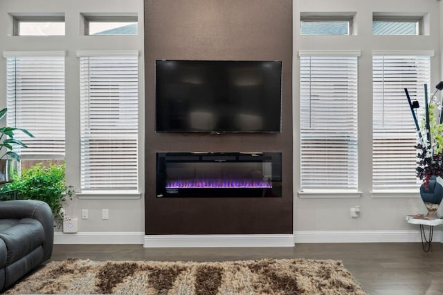 13101 Scissortail Dr, Frisco, TX 75035 - living area with wood finished floors, baseboards, and a glass covered fireplace