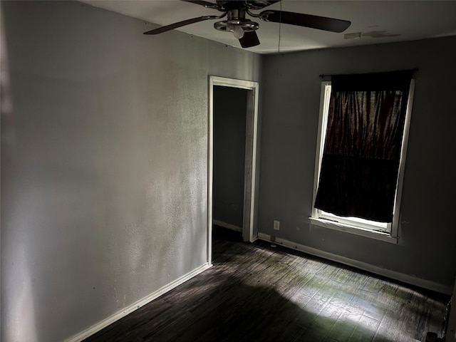 empty room with baseboards, a ceiling fan, and wood finished floors