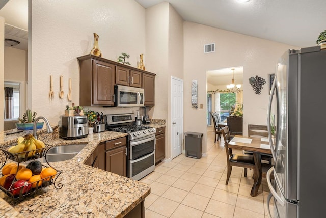 6113 Tilapia Dr, Fort Worth, TX 76179 - kitchen with appliances with stainless steel finishes, light tile patterned floors, a chandelier, a sink, and light stone countertops
