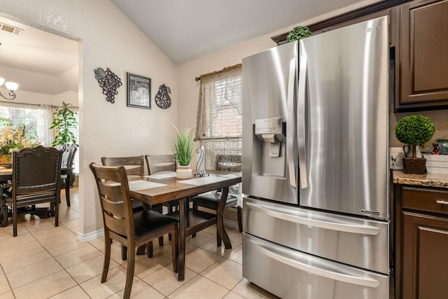 6113 Tilapia Dr, Fort Worth, TX 76179 - kitchen featuring stainless steel refrigerator with ice dispenser, lofted ceiling, light tile patterned floors, a chandelier, and dark brown cabinets