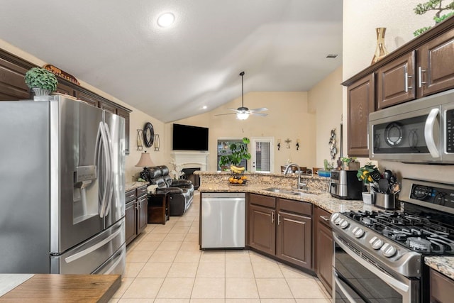 6113 Tilapia Dr, Fort Worth, TX 76179 - kitchen featuring appliances with stainless steel finishes, a sink, vaulted ceiling, light tile patterned floors, and a peninsula