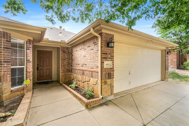 6113 Tilapia Dr, Fort Worth, TX 76179 - property entrance featuring brick siding, roof with shingles, a garage, and driveway