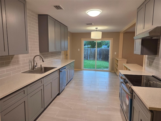 2149 Pueblo Dr, Garland, TX 75040 - kitchen featuring under cabinet range hood, visible vents, a sink, tasteful backsplash, and appliances with stainless steel finishes