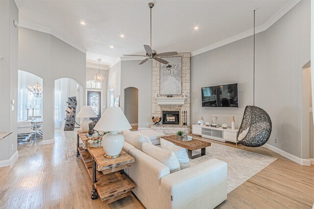 621 E Fm 550, Mclendon Chisholm, TX 75032 - living area with arched walkways, a stone fireplace, plenty of natural light, and ceiling fan with notable chandelier