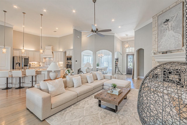 621 E Fm 550, Mclendon Chisholm, TX 75032 - living room with ceiling fan with notable chandelier, crown molding, light wood finished floors, arched walkways, and a high ceiling