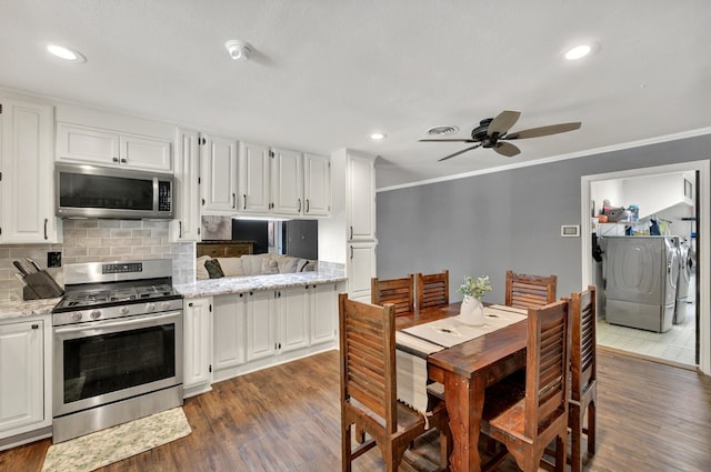 1601 E Bankhead Dr, Weatherford, TX 76086 - kitchen featuring appliances with stainless steel finishes, independent washer and dryer, dark wood finished floors, a ceiling fan, and white cabinetry