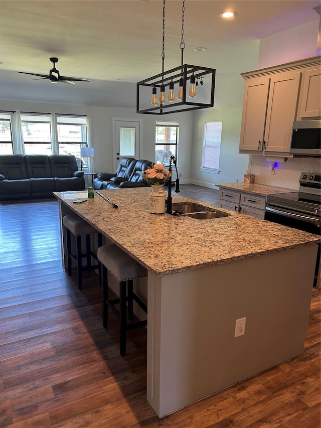 2631 Fish Tank Rd, Corsicana, TX 75110 - kitchen with a sink, open floor plan, appliances with stainless steel finishes, a center island with sink, and light stone countertops