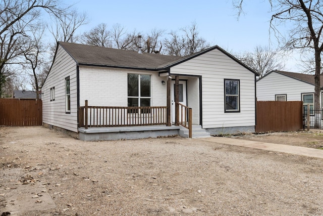 2617 Fordham Rd, Dallas, TX 75216 - view of front facade with a porch, brick siding, roof with shingles, and fence