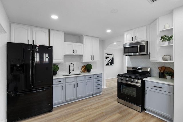 2617 Fordham Rd, Dallas, TX 75216 - kitchen featuring a sink, open shelves, arched walkways, tasteful backsplash, and appliances with stainless steel finishes