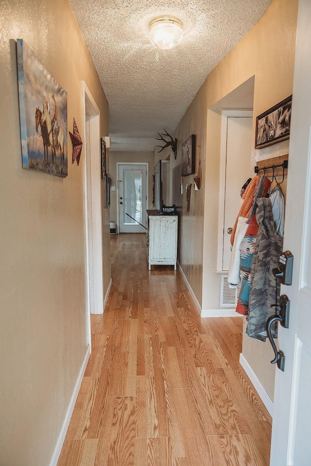 204 County Road 2211, Ivanhoe, TX 75447 - hall featuring a textured ceiling, baseboards, and wood finished floors