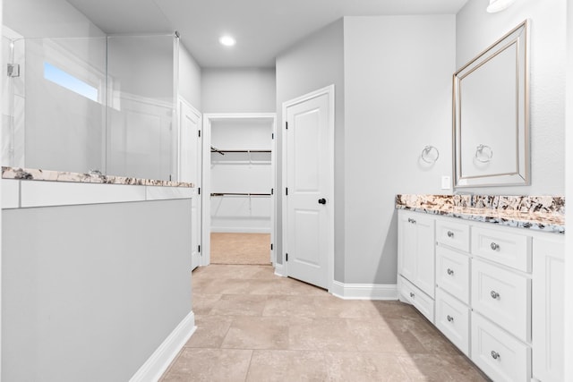 120 Water View Ln, Robinson, TX 76706 - bathroom featuring a walk in closet, a walk in shower, baseboards, vanity, and recessed lighting
