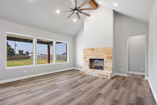 9008 Parkview Cir, Tolar, TX 76476 - unfurnished living room with a stone fireplace, ceiling fan, high vaulted ceiling, wood finished floors, and beamed ceiling