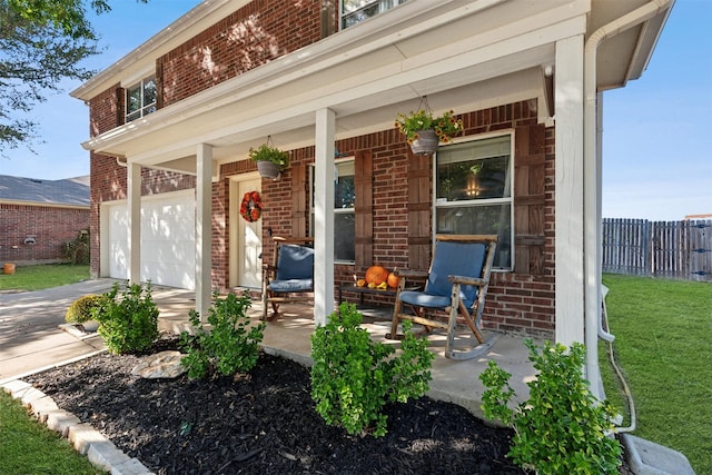 3600 Riesling Dr, Denton, TX 76226 - view of exterior entry featuring a yard, brick siding, fence, covered porch, and a garage