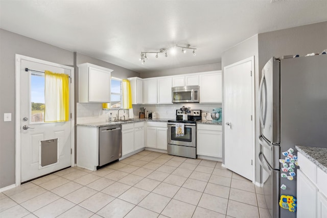 3600 Riesling Dr, Denton, TX 76226 - kitchen featuring a sink, stainless steel appliances, backsplash, white cabinets, and light stone countertops