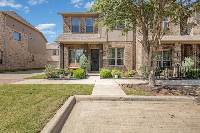 view of front of home featuring brick siding and a front yard
