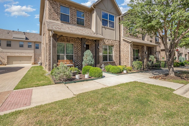 view of front of property featuring a front yard, brick siding, driveway, a garage, and stucco siding