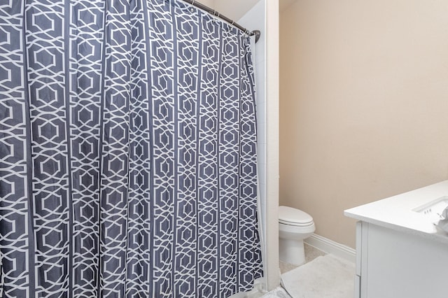 full bath featuring toilet, vanity, a shower with shower curtain, and baseboards