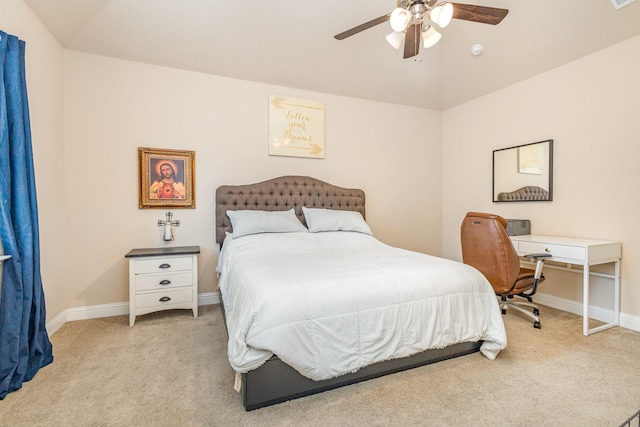 bedroom featuring light carpet, baseboards, vaulted ceiling, and ceiling fan