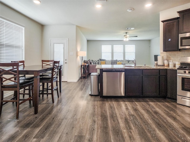 601 Bassett Hall Rd, Fate, TX 75189 - kitchen with dark brown cabinets, a sink, dark wood finished floors, ceiling fan, and appliances with stainless steel finishes