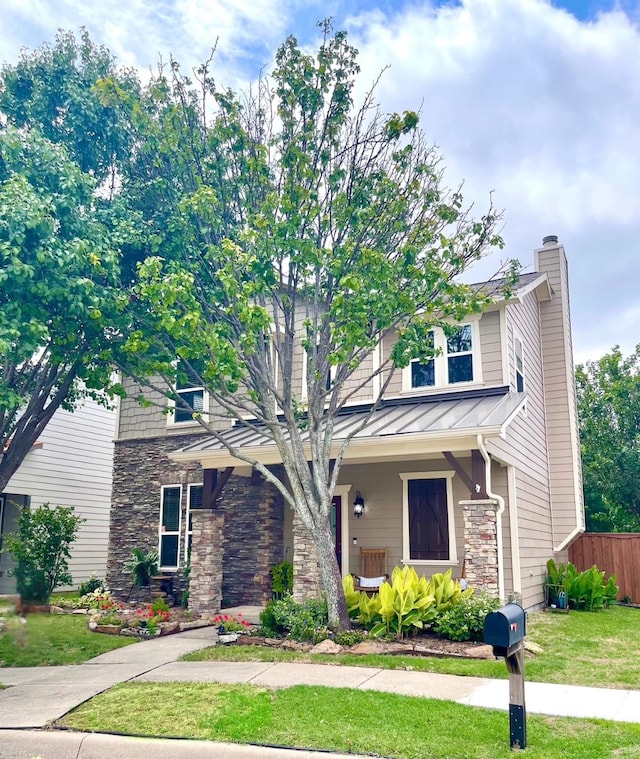 7125 Cotton Seed Dr, Mckinney, TX 75070 - view of front facade with stone siding, a standing seam roof, a chimney, metal roof, and covered porch