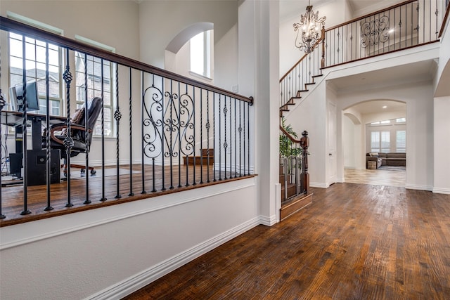 2204 Aberdeen Dr, Trophy Club, TX 76262 - stairs with wood finished floors, baseboards, arched walkways, a chandelier, and a high ceiling