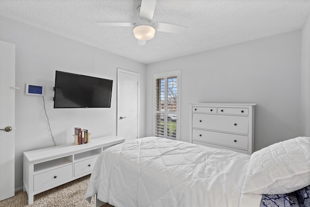 bedroom featuring a textured ceiling, a ceiling fan, and carpet floors