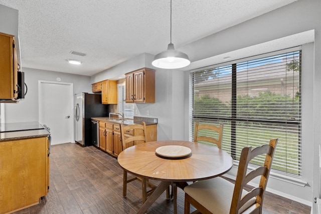 dining space featuring dark wood-style floors and a textured ceiling