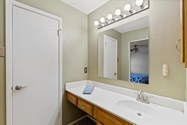 bathroom featuring connected bathroom, ceiling fan, vanity, and a textured ceiling