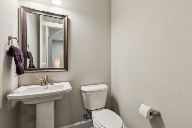 bathroom featuring toilet and baseboards