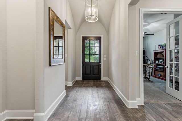 foyer entrance featuring dark wood-style flooring, baseboards, and a chandelier
