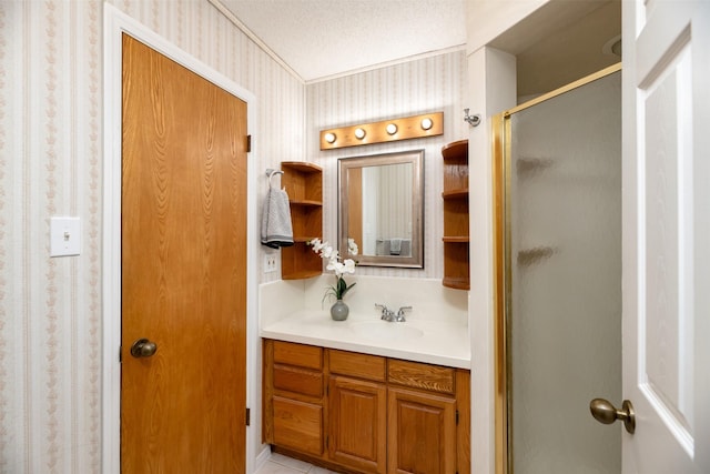 bathroom with wallpapered walls, a stall shower, and vanity