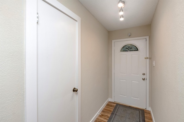 doorway with light wood-style floors and baseboards
