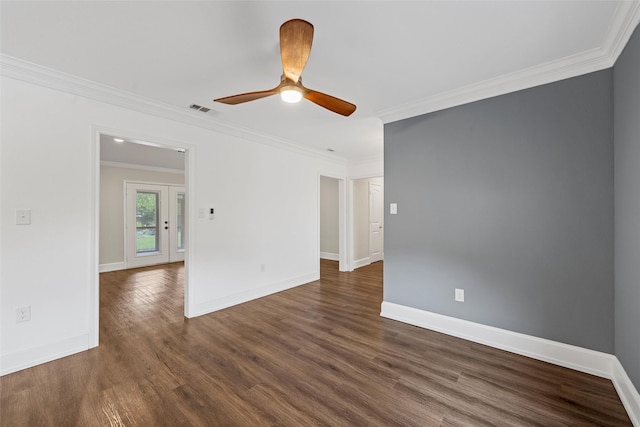 spare room featuring dark wood-type flooring, crown molding, baseboards, and a ceiling fan