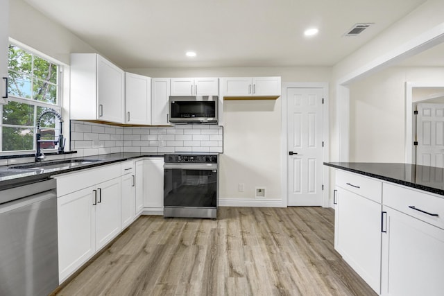 1110 Green St, Abilene, TX 79603 - kitchen featuring stainless steel appliances, a sink, light wood-type flooring, white cabinets, and recessed lighting