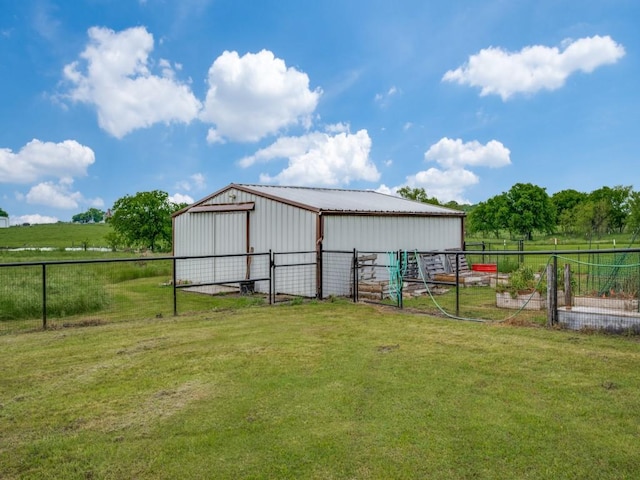 view of pole building featuring a rural view, a lawn, and an exterior structure