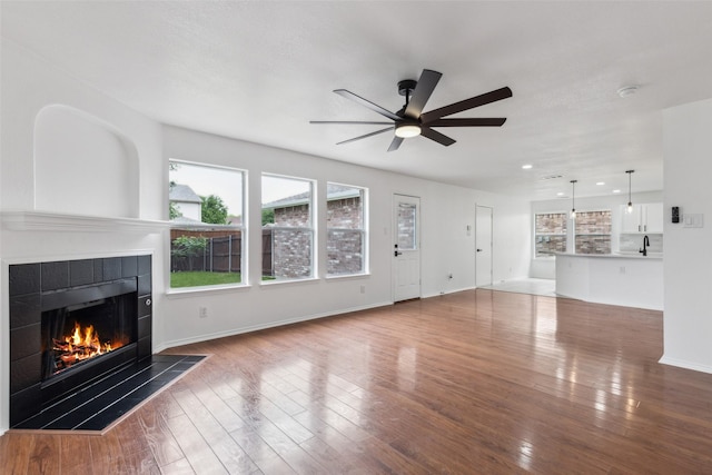 1411 Thistle Cir, Allen, TX 75002 - unfurnished living room featuring a fireplace, ceiling fan, wood finished floors, baseboards, and a sink