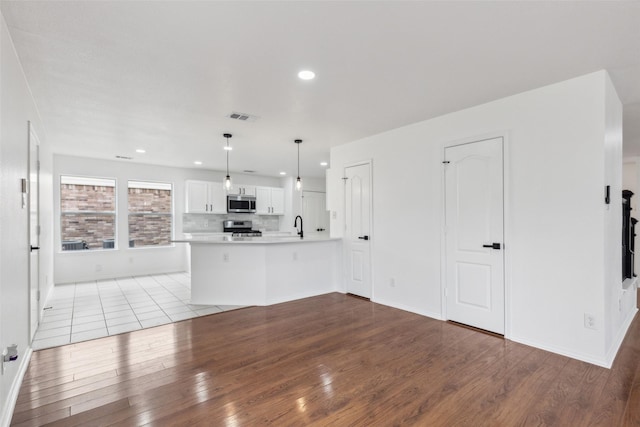 1411 Thistle Cir, Allen, TX 75002 - kitchen featuring stainless steel appliances, light wood finished floors, white cabinetry, light countertops, and recessed lighting