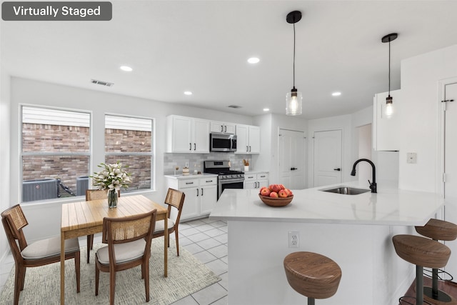 1411 Thistle Cir, Allen, TX 75002 - kitchen with appliances with stainless steel finishes, a sink, a kitchen breakfast bar, white cabinets, and decorative backsplash