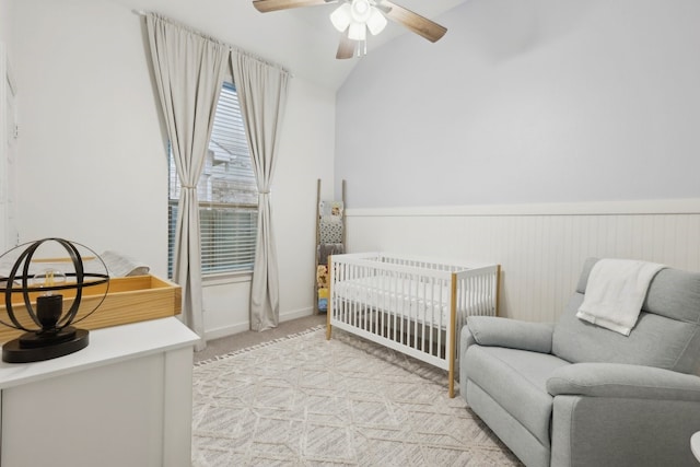 1405 Chickadee Dr, Argyle, TX 76226 - bedroom with a crib, light colored carpet, a wainscoted wall, vaulted ceiling, and a ceiling fan
