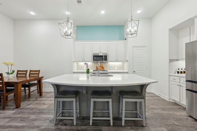 1405 Chickadee Dr, Argyle, TX 76226 - kitchen featuring appliances with stainless steel finishes, a chandelier, tasteful backsplash, a kitchen breakfast bar, and recessed lighting