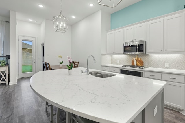 1405 Chickadee Dr, Argyle, TX 76226 - kitchen with stainless steel appliances, a sink, dark wood finished floors, an island with sink, and backsplash