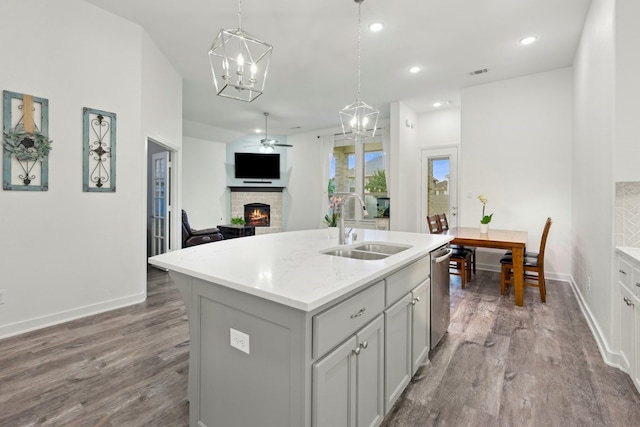 1405 Chickadee Dr, Argyle, TX 76226 - kitchen featuring a sink, a brick fireplace, dishwasher, a ceiling fan, and wood finished floors