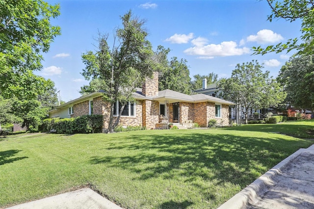 ranch-style home with a front lawn, a chimney, and brick siding