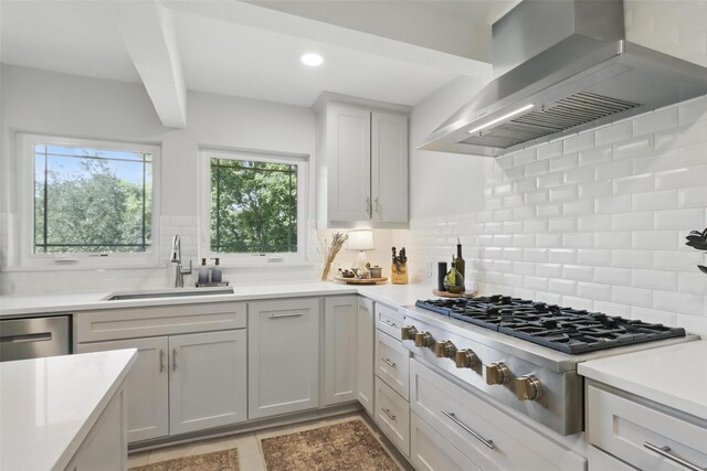 kitchen featuring appliances with stainless steel finishes, a sink, gray cabinetry, a breakfast bar area, and light countertops
