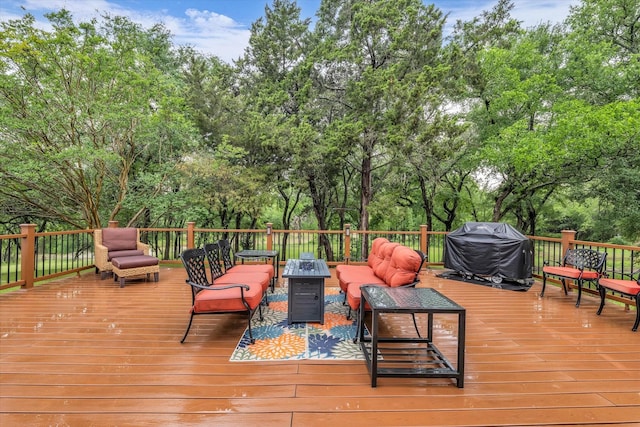 deck with an outdoor hangout area, view of wooded area, and area for grilling