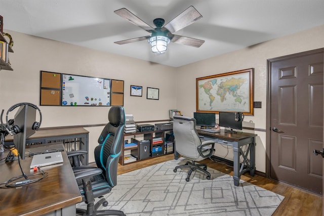 office with wood finished floors, a ceiling fan, and baseboards