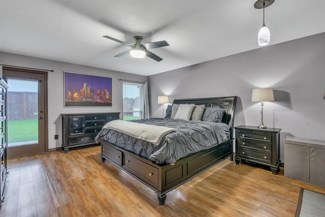 bedroom with access to exterior, wood finished floors, ceiling fan, and baseboards