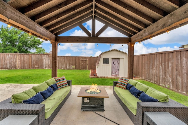 view of patio with an outdoor living space with a fire pit, a gazebo, a storage shed, and an outbuilding