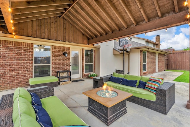 view of patio with an outdoor living space with a fire pit and fence